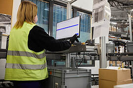 Zamestnanec plánujúci procesy automatizovaného skladu s kontajnermi od bekuplastu